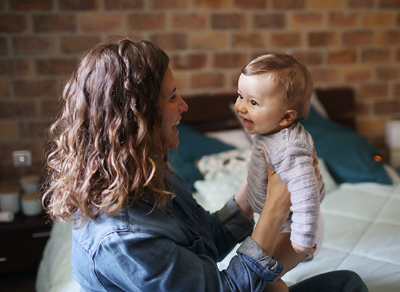 Happy babysitter holds child