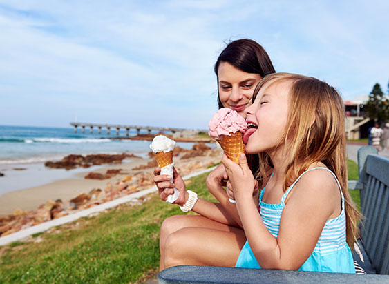 Nanny and child eat ice cream in summer