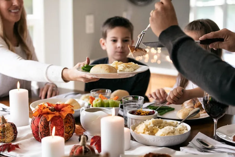 Family enjoying Thanksgiving dinner with turkey and vegetables