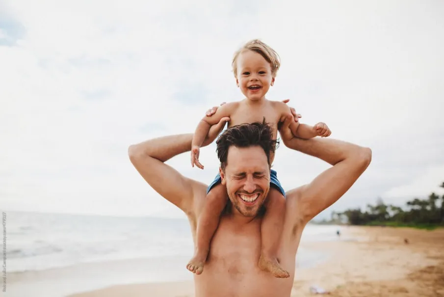 Father and child enjoying a playful moment on the beach