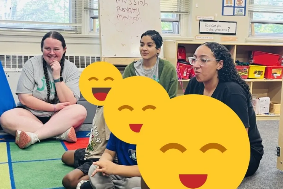 Adults sitting on classroom floor with children