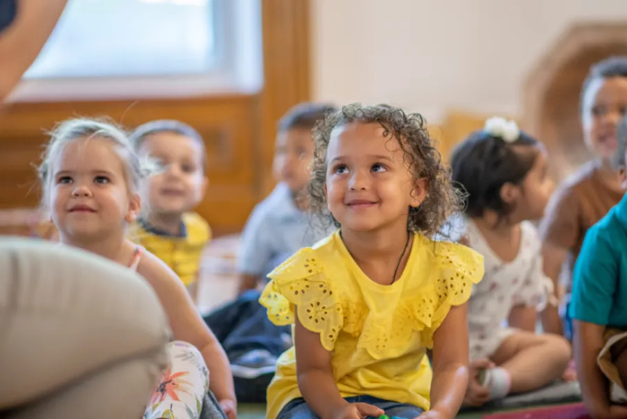 Children sitting and listening attentively in a classroom
