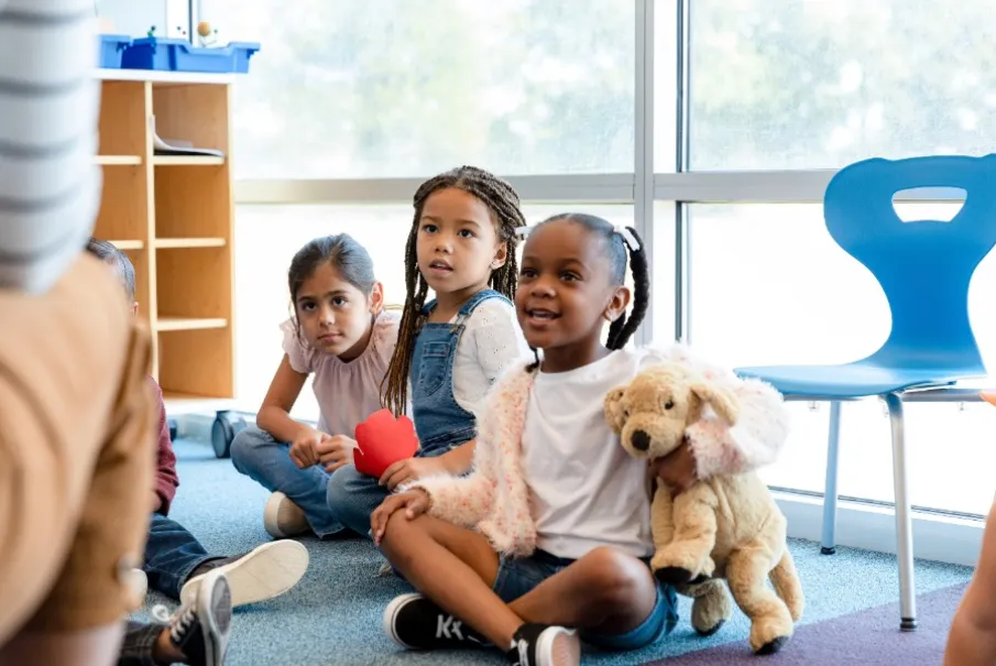 Children engaged in a classroom activity sitting on the floor