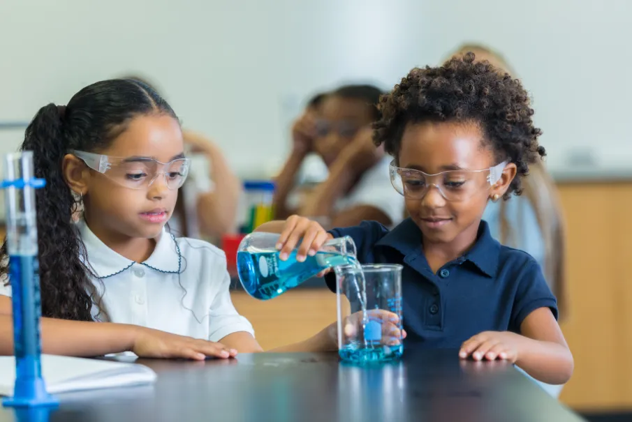 Children conducting a science experiment in a classroom with protective eyewear
