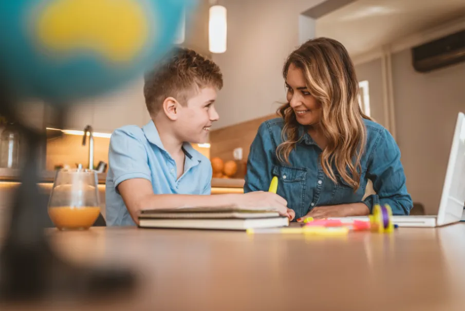 Mother helping son with homework in kitchen