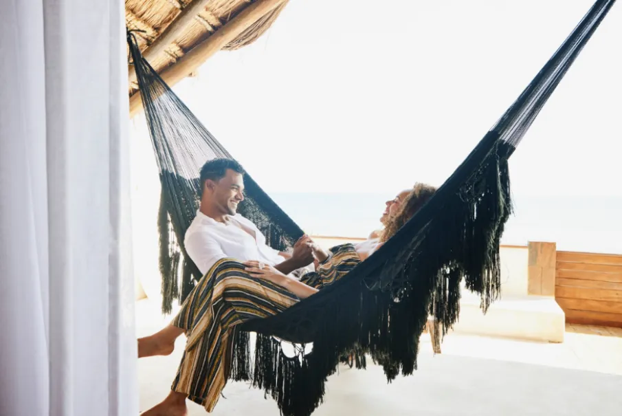 Couple relaxing in hammock at beachfront