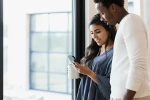 Two people looking at smartphone indoors