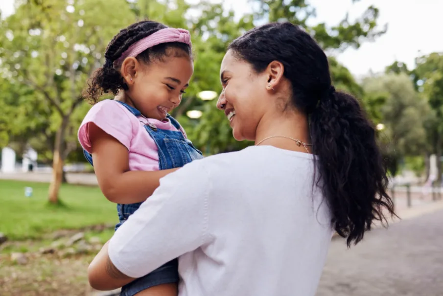 Mother and daughter smiling in park