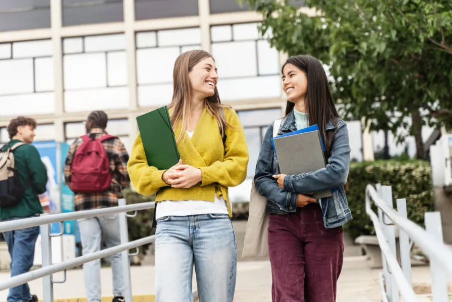 Students walking and smiling outside a university building